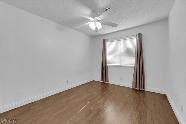 empty room with ceiling fan, hardwood / wood-style floors, and a textured ceiling