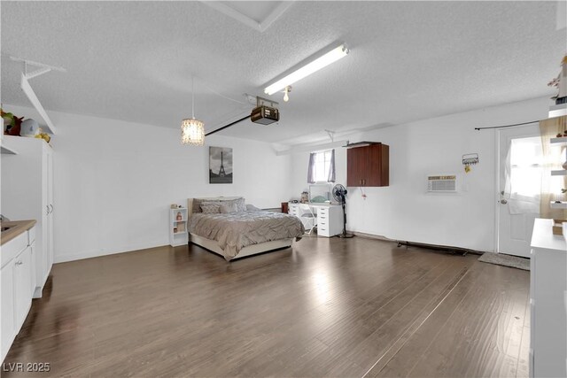 bedroom featuring a textured ceiling and dark hardwood / wood-style flooring