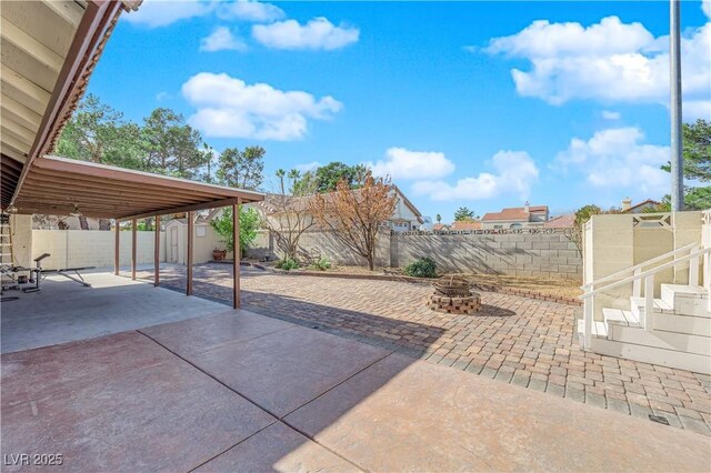 view of patio / terrace with a storage unit and a fire pit