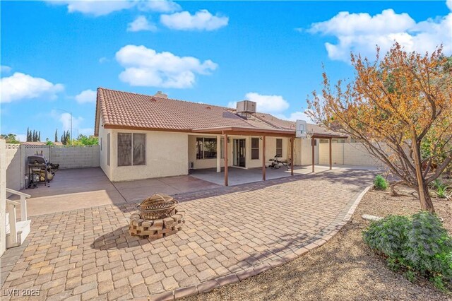 back of house featuring a fire pit and a patio