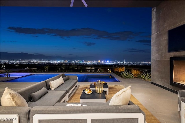 view of swimming pool featuring a patio area and an outdoor living space with a fireplace