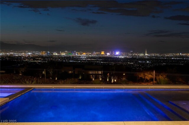 view of pool at twilight