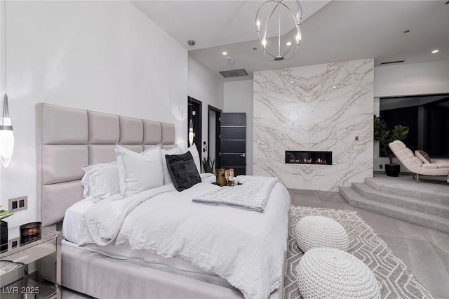 bedroom featuring a fireplace and an inviting chandelier