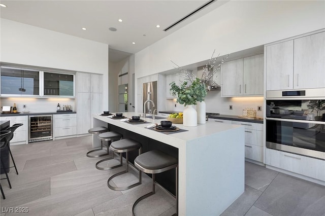 1 Boulderback Dr, Henderson, NV 89012 - kitchen with wine cooler, modern cabinets, stainless steel appliances, a breakfast bar area, and recessed lighting