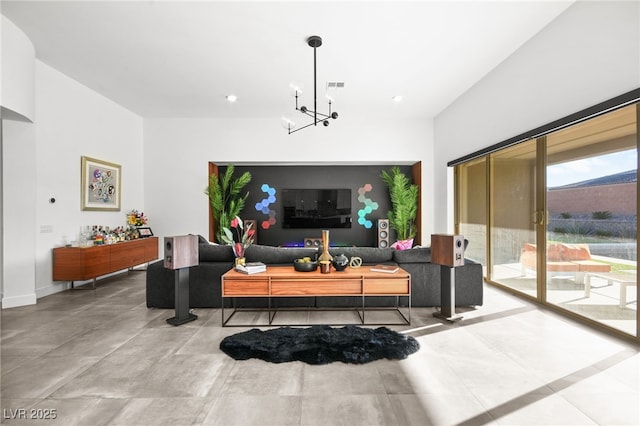 living room featuring an inviting chandelier and concrete floors