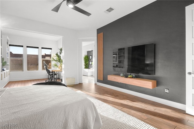 bedroom with ceiling fan, radiator, and light hardwood / wood-style floors