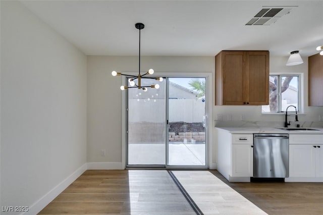 kitchen with white cabinetry, sink, hanging light fixtures, a chandelier, and stainless steel dishwasher