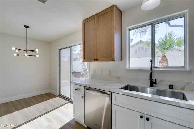 kitchen featuring dishwasher, white cabinetry, sink, hanging light fixtures, and a chandelier