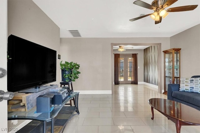 tiled living room featuring ceiling fan and french doors