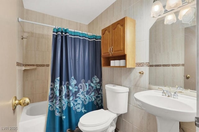 full bathroom featuring toilet, sink, tile walls, and shower / bath combo with shower curtain