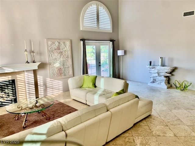 living room with a towering ceiling and french doors