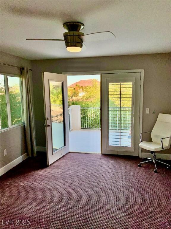 doorway with ceiling fan, a mountain view, and carpet flooring