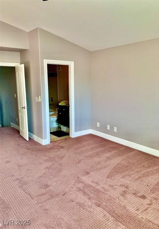 unfurnished bedroom featuring carpet floors, a closet, and lofted ceiling