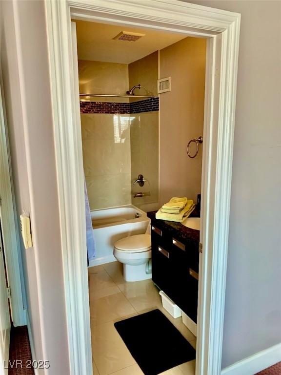 bathroom with toilet, tile patterned floors, and shower / tub combo with curtain