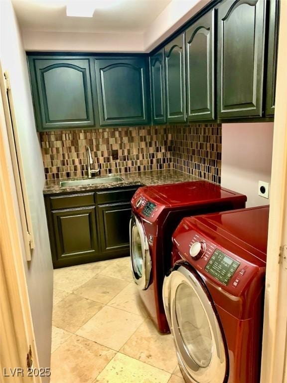 clothes washing area with cabinets, light tile patterned floors, sink, and washing machine and dryer