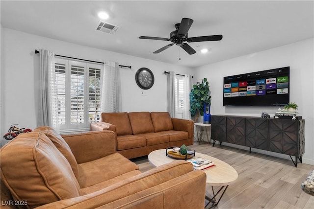 living room with ceiling fan and light hardwood / wood-style flooring