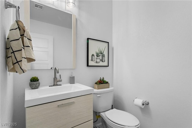 bathroom featuring toilet and vanity