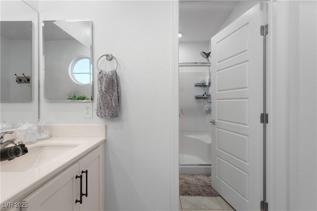 bathroom featuring tile patterned floors, an enclosed shower, and vanity