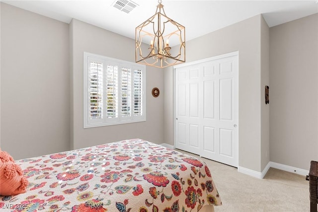 carpeted bedroom with a closet and a chandelier