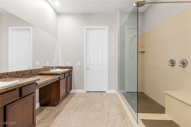 bathroom with walk in shower, vanity, and tile patterned flooring