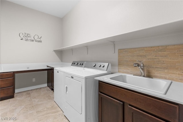 laundry room with cabinets, washer and dryer, and sink