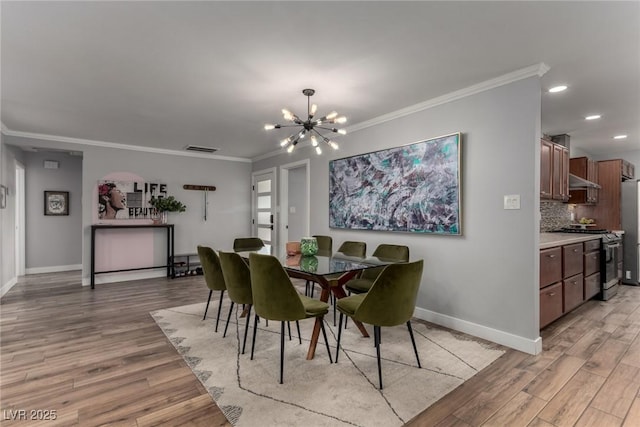 dining space featuring a notable chandelier, crown molding, and light hardwood / wood-style floors