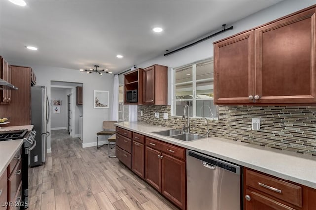 kitchen with sink, light hardwood / wood-style flooring, stainless steel appliances, and tasteful backsplash