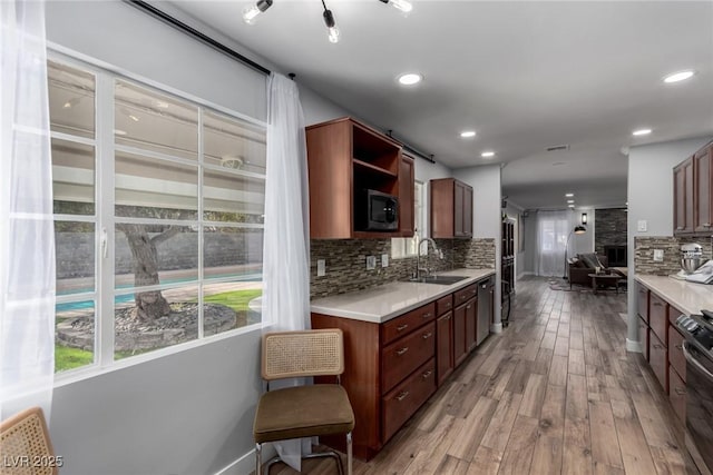 kitchen featuring decorative backsplash, sink, light hardwood / wood-style flooring, and stainless steel appliances