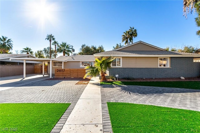 ranch-style home with a front yard and a carport