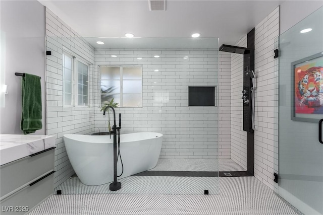 bathroom featuring tile patterned flooring, vanity, tile walls, and independent shower and bath