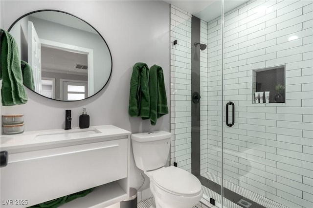 bathroom with walk in shower, vanity, and toilet