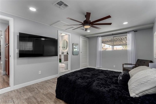 bedroom with ceiling fan, ensuite bathroom, and light hardwood / wood-style flooring