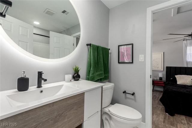 bathroom with hardwood / wood-style flooring, toilet, vanity, and ceiling fan