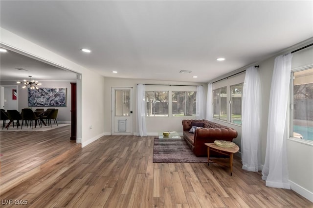 sitting room with hardwood / wood-style floors and an inviting chandelier