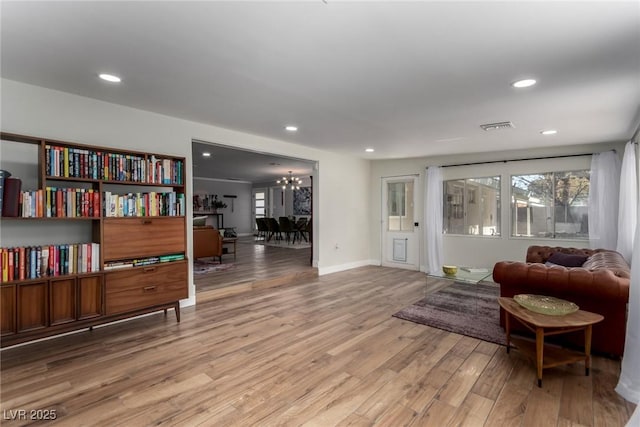 living area featuring light hardwood / wood-style floors and a notable chandelier