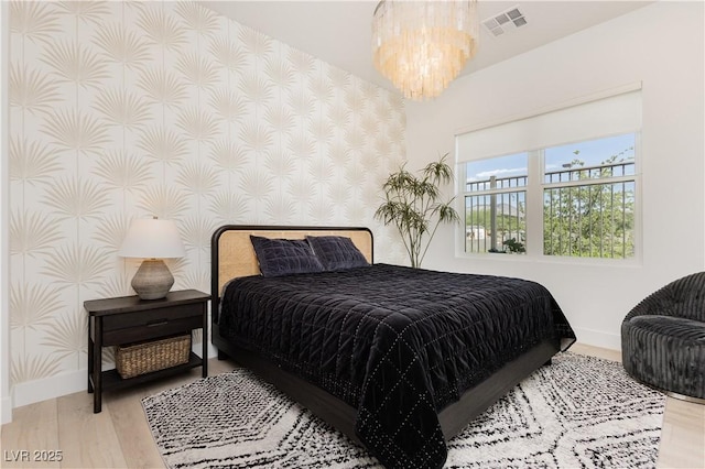 bedroom with an inviting chandelier and wood-type flooring