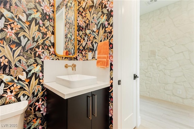 bathroom featuring wood-type flooring, toilet, and vanity