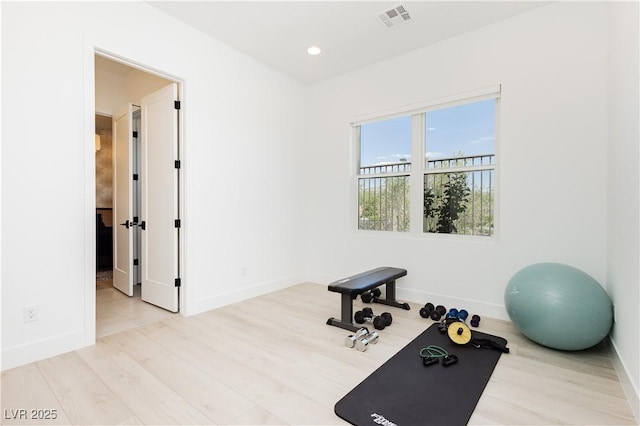 exercise room with light hardwood / wood-style floors