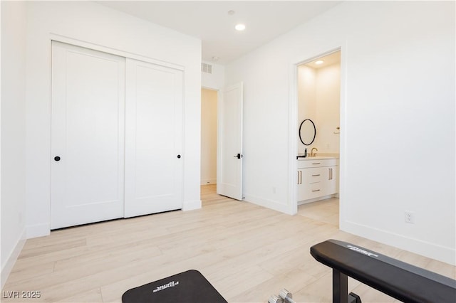 workout room featuring light hardwood / wood-style flooring and sink