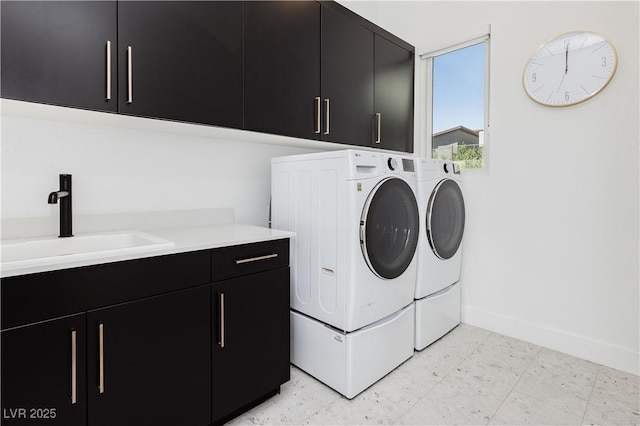 washroom with cabinets, washing machine and clothes dryer, and sink