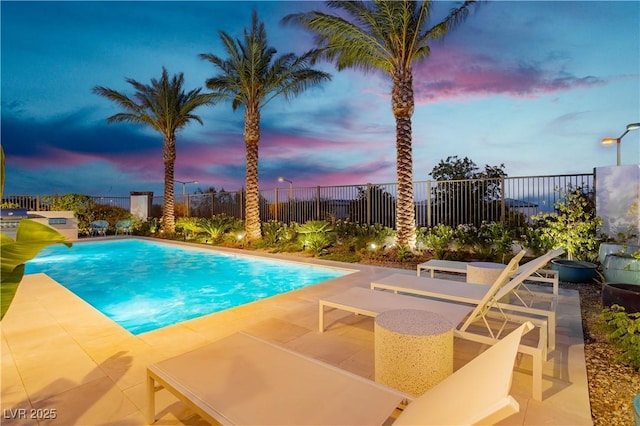 pool at dusk with a patio