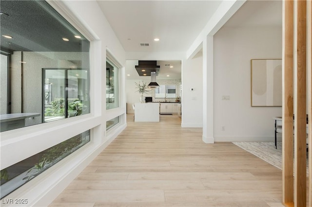 corridor with light hardwood / wood-style floors