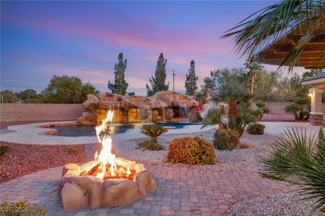 yard at dusk featuring a fire pit