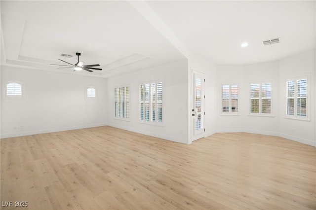 unfurnished living room featuring ceiling fan, light hardwood / wood-style flooring, and a raised ceiling