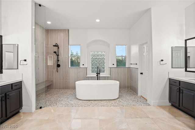 bathroom featuring vanity and independent shower and bath