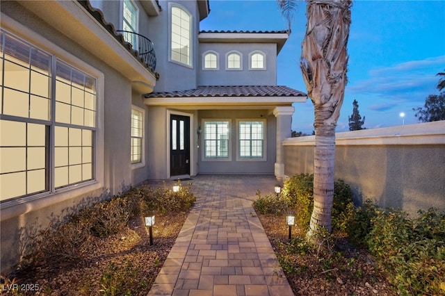 view of exterior entry featuring a balcony