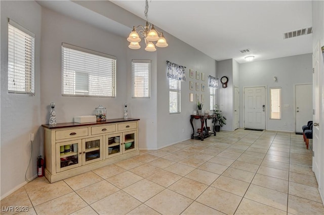 tiled entrance foyer with a chandelier