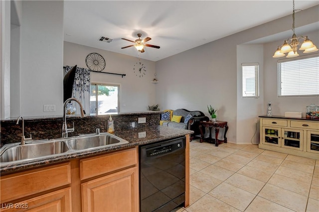 kitchen featuring ceiling fan with notable chandelier, black dishwasher, dark stone counters, sink, and light tile patterned floors