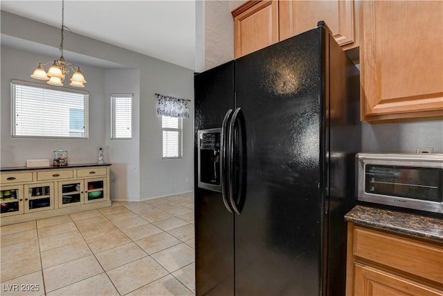 kitchen with black refrigerator with ice dispenser, light tile patterned flooring, hanging light fixtures, dark stone counters, and a chandelier