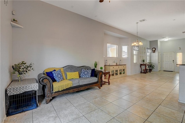 living room with light tile patterned floors and ceiling fan with notable chandelier